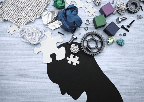 Tools puzzles pieces and other items above a silhouette head